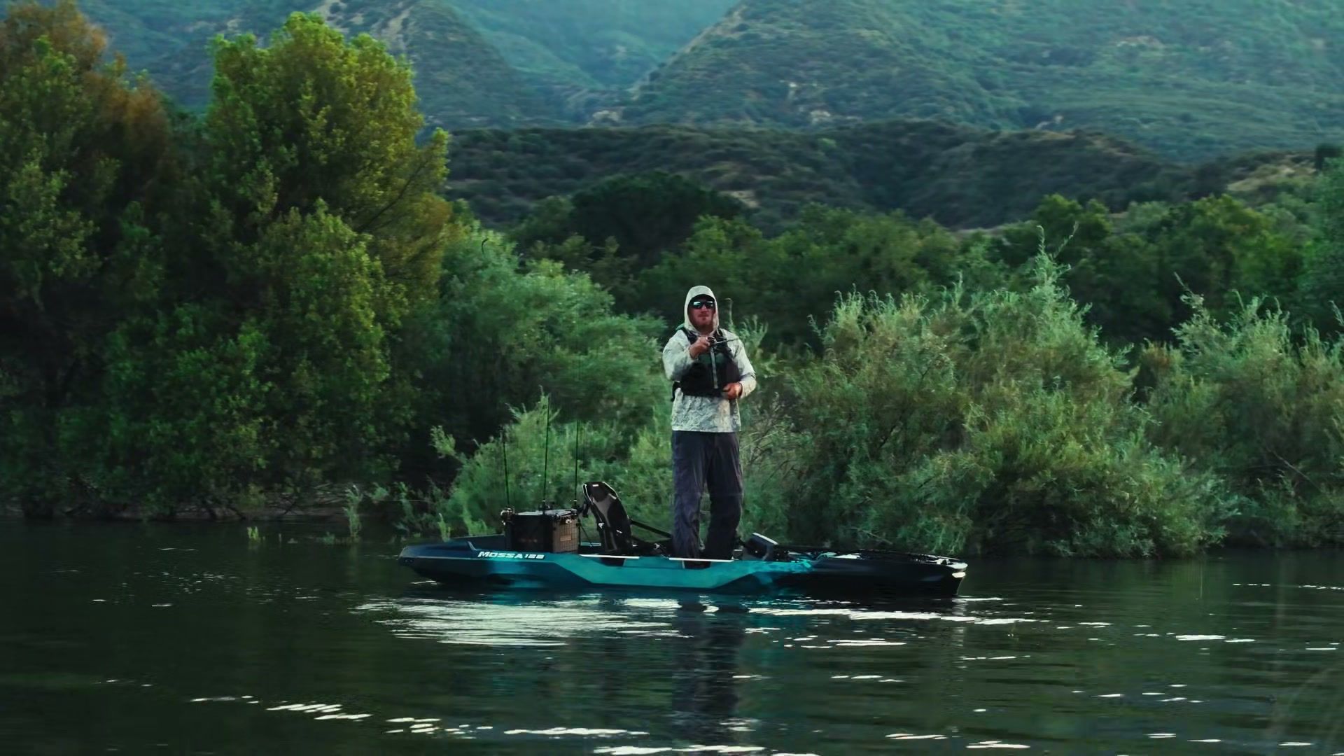Angler standing on a VoyaX MOSSA 128 fishing a brushy bank