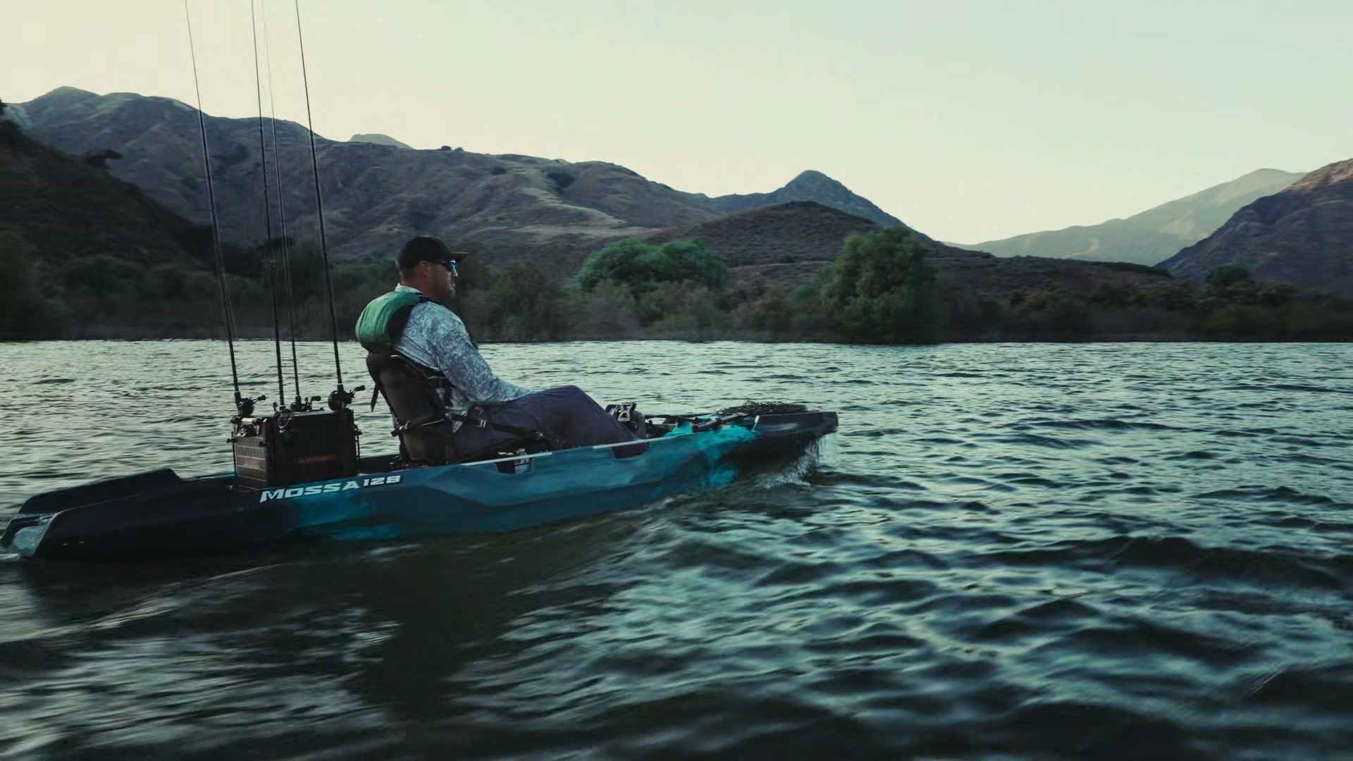 Angler riding a VoyaX MOSSA 128 across open water with rods rigged